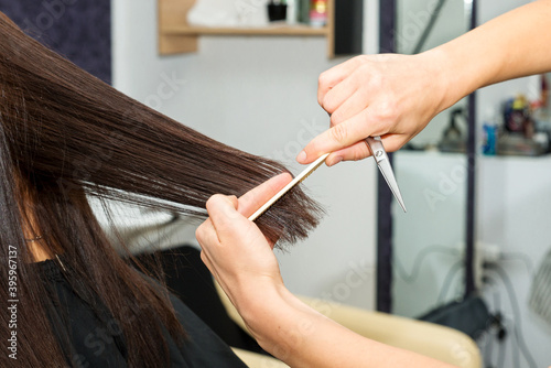 Close-up of female hands of hairdresser while cutting female hair