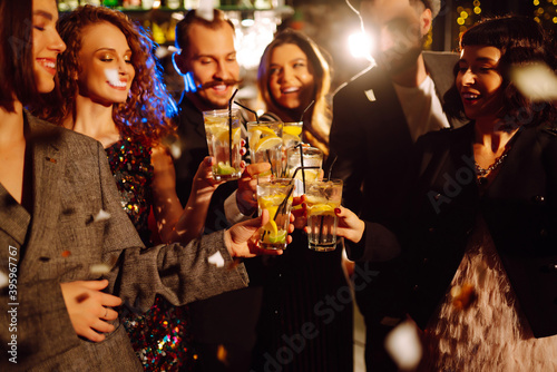 Papier peint Happy friends cheering and drinking cocktails enjoying party in the club