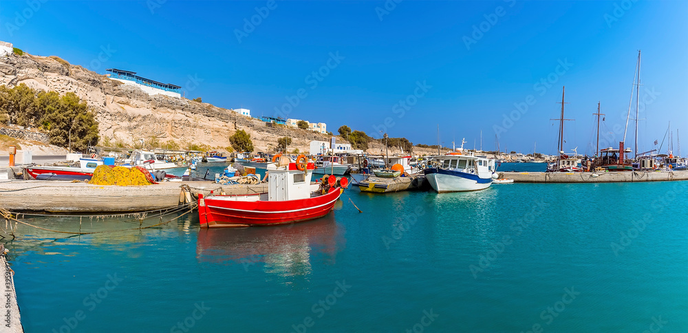 A view of small fishing vessels moored in the harbour at Vlychada in Santorini in summertime