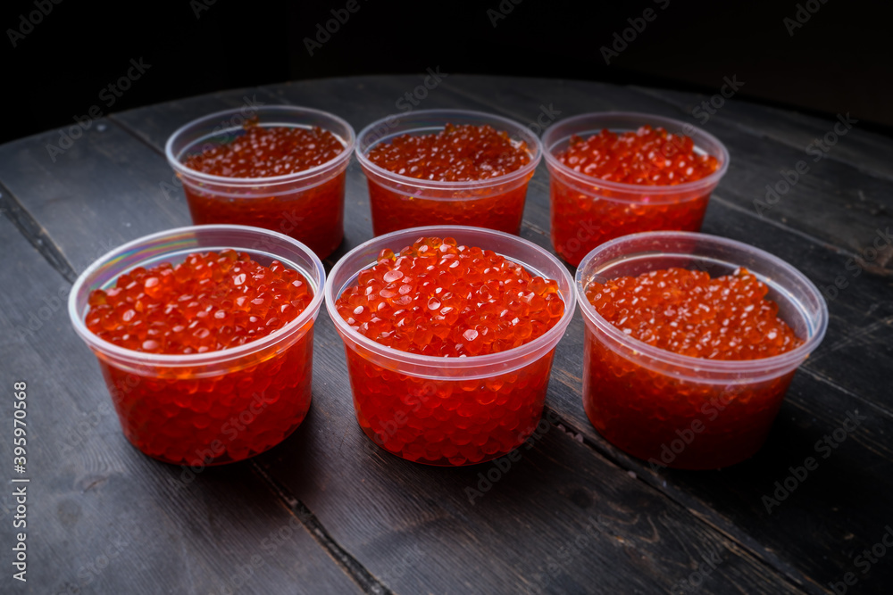 Pink salmon caviar and chum salmon caviar in plastic containers. Seafood, delicacies, healthy nutrition. Pink salmon caviar and chum salmon caviar in plastic containers. Seafood, delicacies, healthy nutrition.