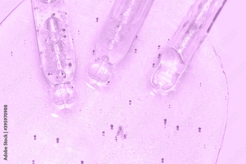 close up macro of pipette dropper with liquid with particles on a purple background close up macro of pipette dropper with liquid with particles on a purple background