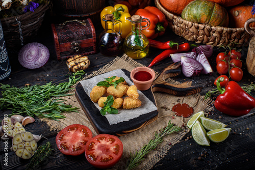 fried cheese sticks on a wooden table with vegetables