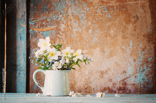 spring flowers in jug on old wooden painted background © Maya Kruchancova