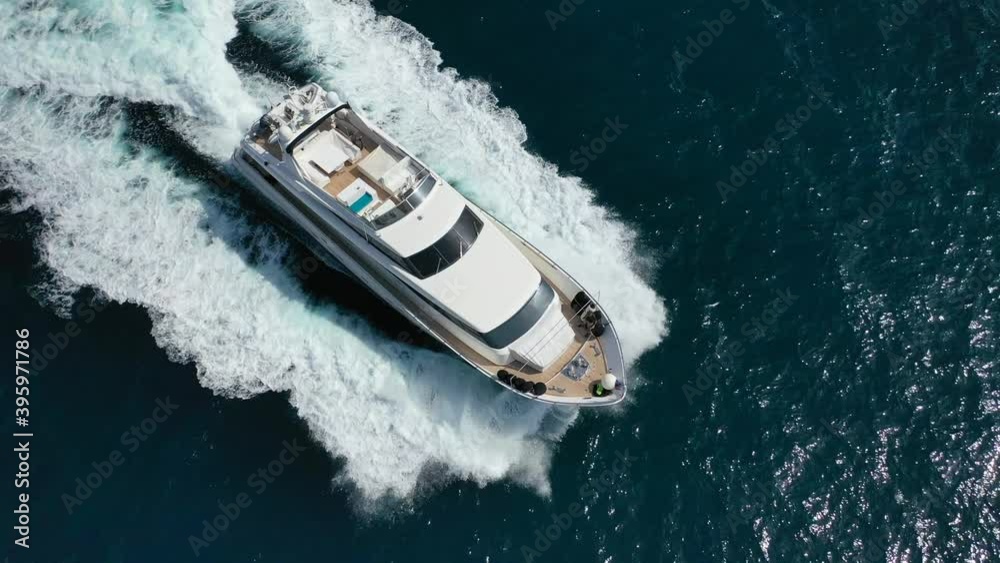 Aerial tracking top down video of luxury yacht cruising in deep blue open ocean sea Aerial tracking top down video of luxury yacht cruising in deep blue open ocean sea