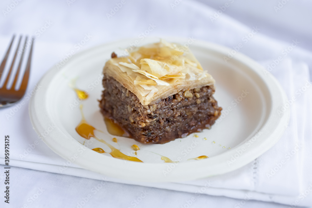 A view of a plate of baklava, in a restaurant or kitchen setting.