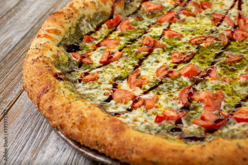A closeup view of tomato and pesto pizza.