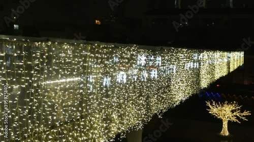 luminous bright snowflakes yellow coloured light bulbs of garland. Christmas street decorations, new year preparation in city. Decorated bridge in the evening