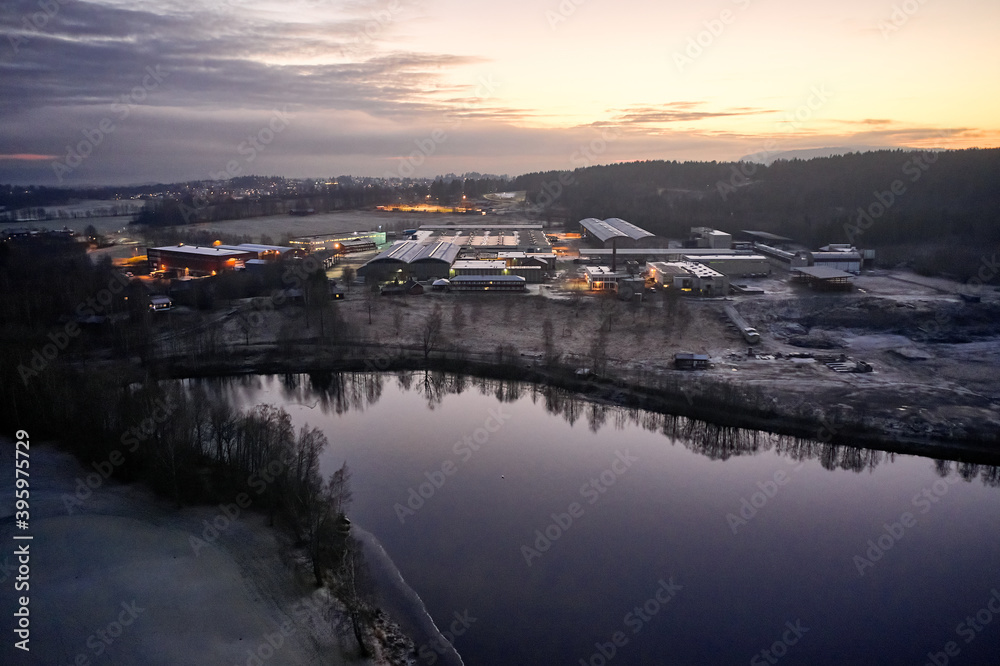 Drone or aerial photo from Oslo, Norway. Shot in late November in blue hours.  Winter is coming. Ground and trees are covered with snow frost, the lakes are freezing up.