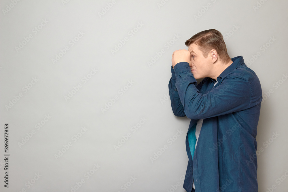 Portrait of serious man making binoculars with hands and looking afar Portrait of serious man making binoculars with hands and looking afar