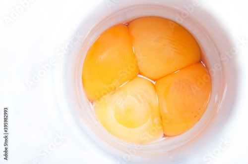 Four egg yolks in a white container