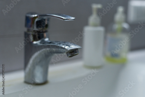 Old dirty washbasin with rust stains  limescale and soap stains in the bathroom with a faucet  water tap.