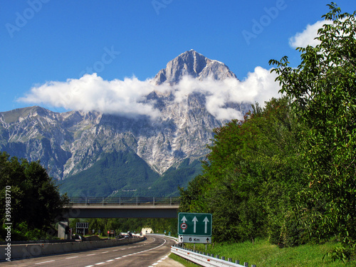 Gran Sasso de Italia. Montaña más alta de los Apeninos visto desde la autopista con nubes a media altura en un día soleado photo
