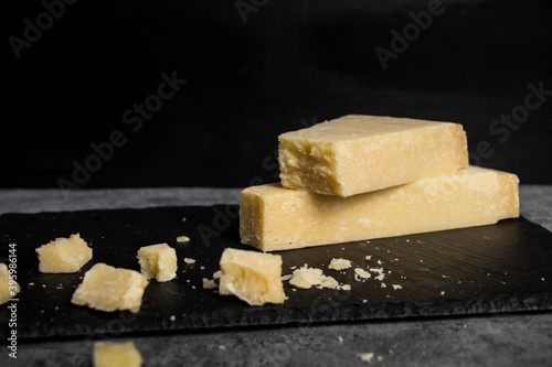 Grana Padano italian hard cheese on dark background