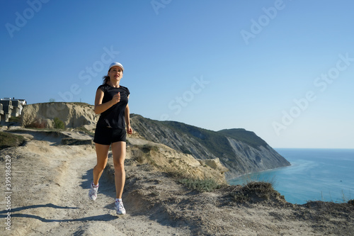 woman on a jogging trip in the mountains on the coast of the sea