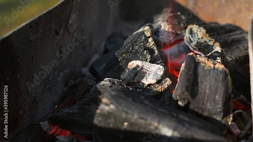 Bright hot coals and burning woods in bbq grill pit