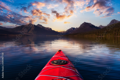 Kayaking in Lake McDonald with American Rocky Mountains in the background. Colorful Sunrise Sky Art Render. Taken in Glacier National Park, Montana, USA.