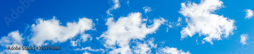 White clouds on a blue sky in bright colors  panorama