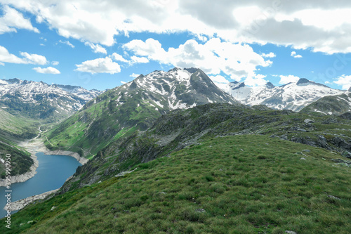 Dam in Austrian Alps. The artificial lake stretches over a vast territory, shining with navy blue color. The dam is surrounded by high mountains. In the back there is a glacier. Controlling the nature photo