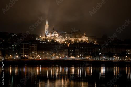 Floodlit Fisherman's Bastion of Budapest during a cold night of November in Hungary, with the river Danube in the foreground