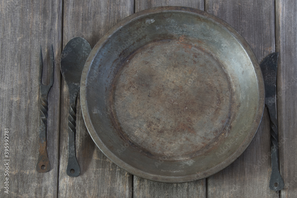 Rustic dinnerware on a weathered table top. Empty. Rustic dinnerware on a weathered table top. Empty.