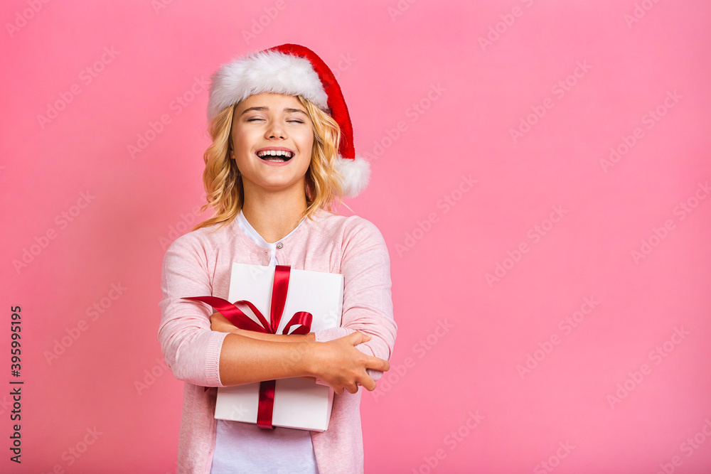 Excited funny kid child girl wears santa hat holding many gift box celebrating happy 2021 New Year isolated on pink background. Merry Christmas presents shopping sale. Excited funny kid child girl wears santa hat holding many gift box celebrating happy 2021 New Year isolated on pink background. Merry Christmas presents shopping sale.