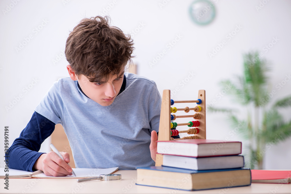 Schoolboy with abacus studying math at home Schoolboy with abacus studying math at home