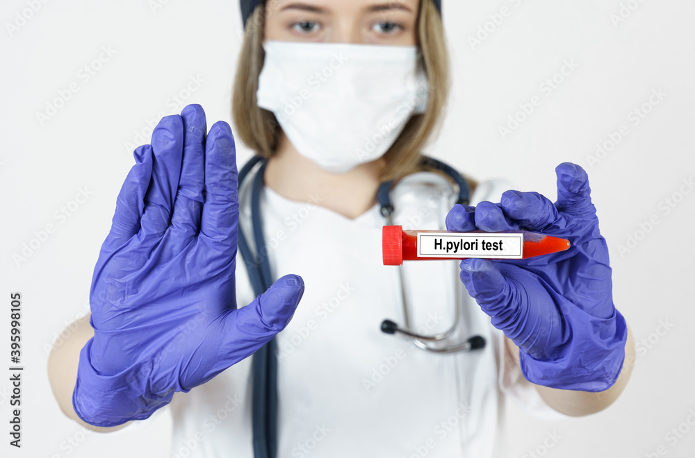 The doctor holds in his hands a test tube with blood tests for the virus -H.pylori, with the other hand he makes a gesture - stop. The doctor holds in his hands a test tube with blood tests for the virus -H.pylori, with the other hand he makes a gesture - stop.