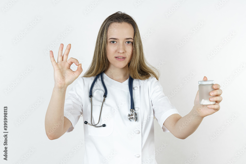 Medicine and health concept. Doctor woman holds pills in her hands, shows gesture - OK. Medicine and health concept. Doctor woman holds pills in her hands, shows gesture - OK.