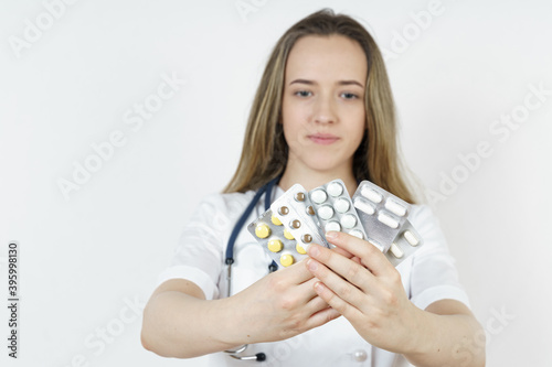 Medicine and health concept. Doctor woman holds pills in hands.