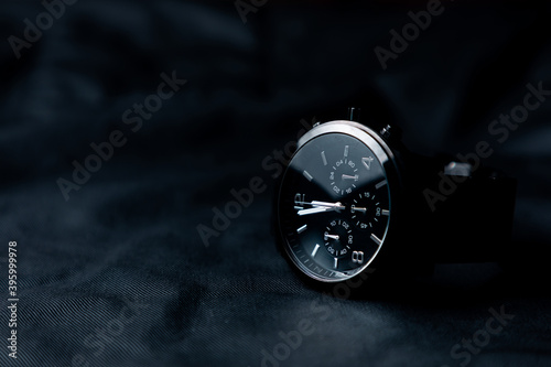 Reloj de pulsera negro elegante sobre fondo negro. Accesorios para hombre.