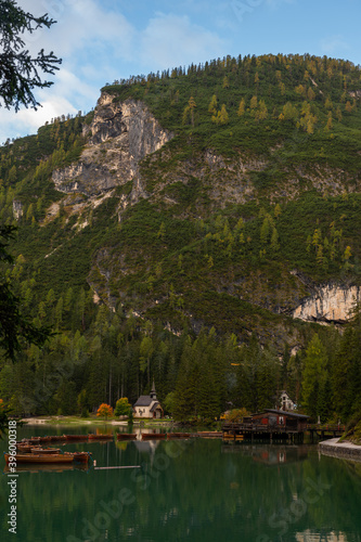 Little chapel and boatshouse at Lake Braies (Pragser Wildsee, Lago di Braies) with boats in foreground. Region of Trentino Alto Adige, Dolomites, Italy photo
