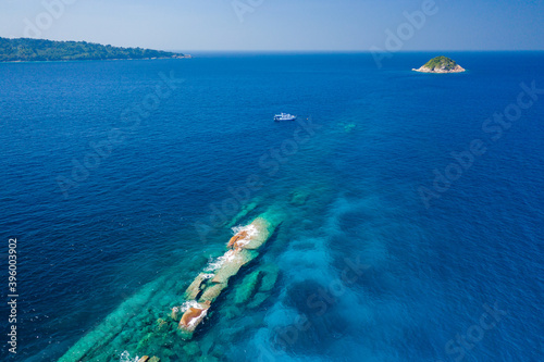 Tropical coral reef in a clear ocean with a distant dive boat