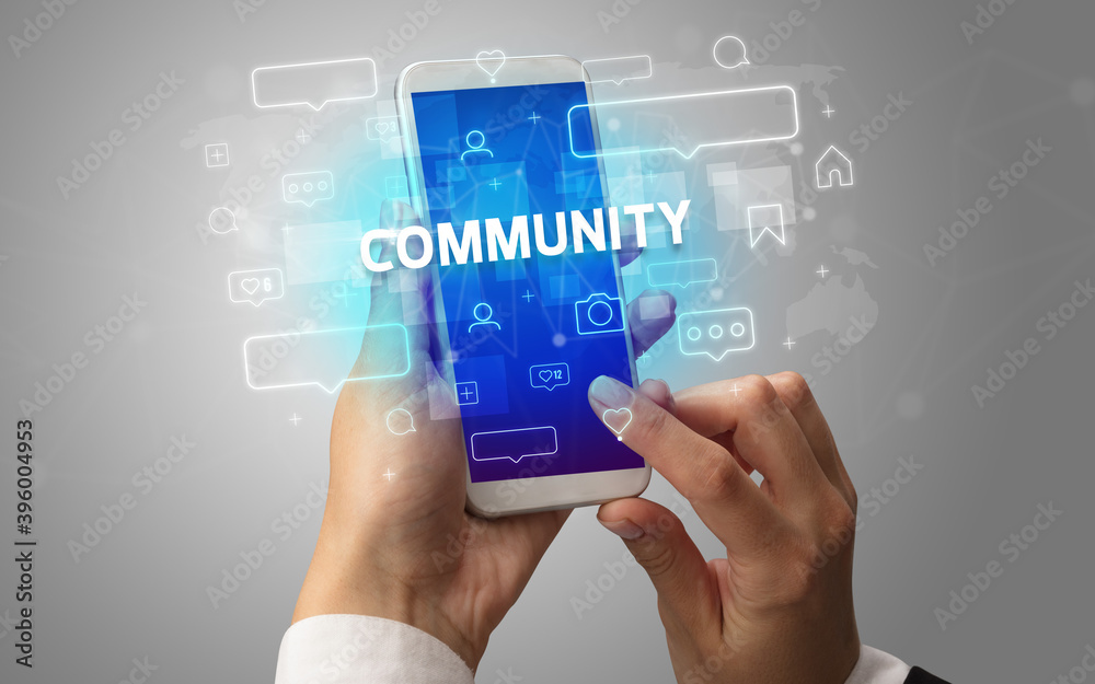 Female hand typing on smartphone with COMMUNITY inscription, social media concept Female hand typing on smartphone with COMMUNITY inscription, social media concept
