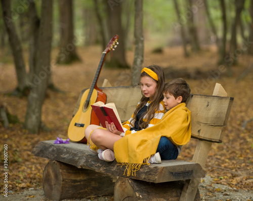 Autumn Portrait of children reading books in the forest, Children Reading from Books Together in the Park,