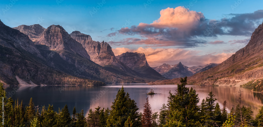 Beautiful Panoramic View of a Glacier Lake with American Rocky Mountain Landscape in the background. Dramatic Colorful Sunrise Sky. Taken in Glacier National Park, Montana, United States. - obrazy, fototapety, plakaty 