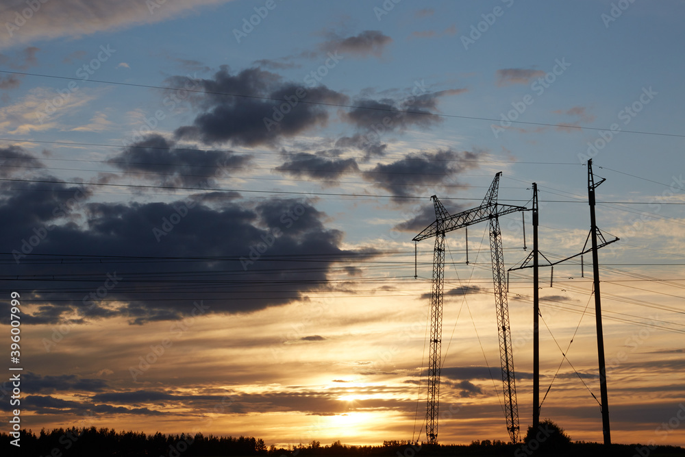 Electricity poles with wires at sunset. Cables or wires are connected between each specific column of electricity against the background of the sunset sky
