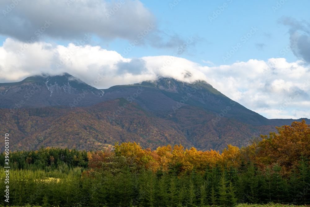 秋の知床　雲がかかった紅葉の知床連山と開拓地跡（北海道・斜里町）
