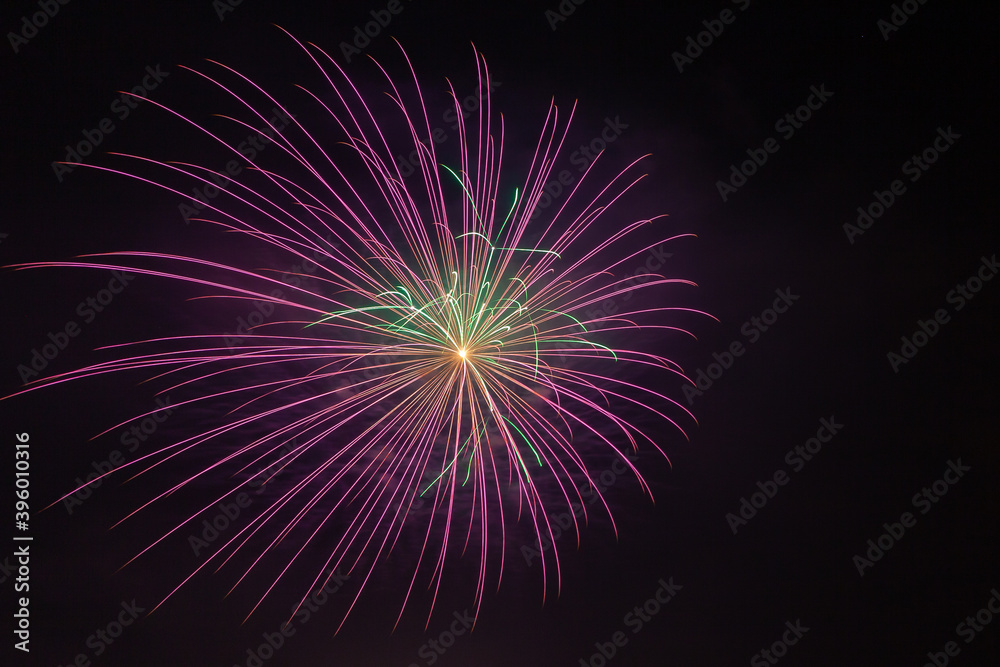 Bright purple and green fireworks against the backdrop of the night sky, Vittorio Veneto, Italy Bright purple and green fireworks against the backdrop of the night sky, Vittorio Veneto, Italy