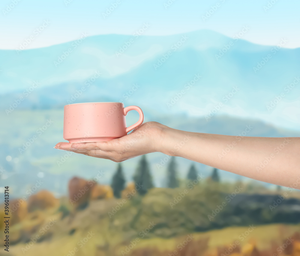 Closeness to nature. Woman holding cup in mountains, closeup Closeness to nature. Woman holding cup in mountains, closeup