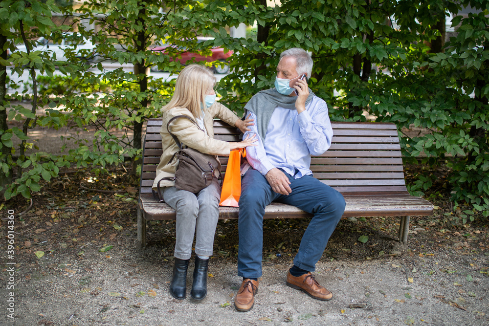 Social distancing and separation concept, coronavirus prevention while sitting on a bench in a park Social distancing and separation concept, coronavirus prevention while sitting on a bench in a park