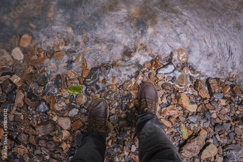 
shoes of a man crossing a mountain glen