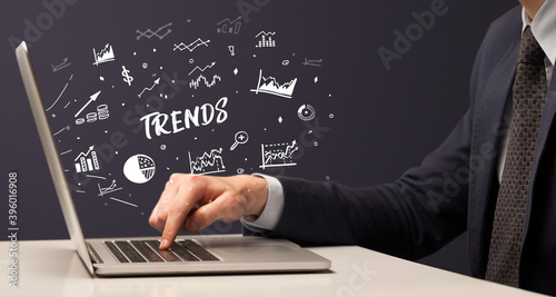 Businessman working on laptop with TRENDS inscription, modern business concept