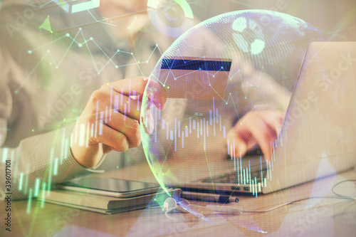 Double exposure of man hands holding a credit card and Forex graph drawing. Stock trading and digital fintech in Internet E-commerce concept.