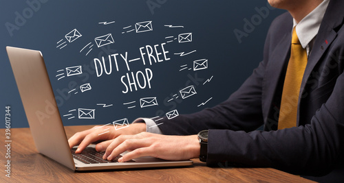 Businessman working on laptop with DUTY-FREE SHOP inscription, online shopping concept