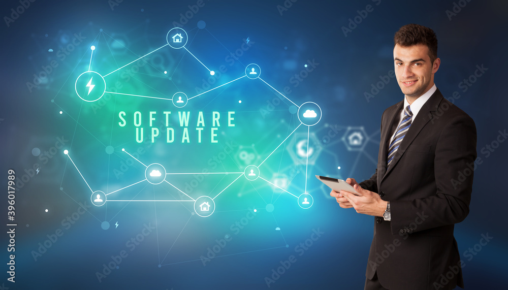 Businessman in front of cloud service icons with SOFTWARE UPDATE inscription, modern technology concept Businessman in front of cloud service icons with SOFTWARE UPDATE inscription, modern technology concept