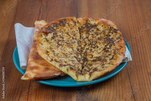 Manakish Zaatar | Lebanese Traditional Breakfast Thyme Pastry in plate over natural wood table