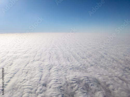 Aerial view above layer of altocumulus clouds with unique texture at midday