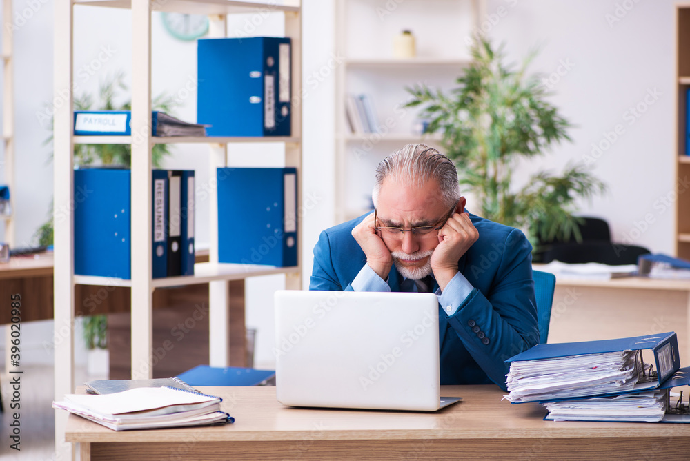 Old male bookkeeper unhappy with excessive work at workplace Old male bookkeeper unhappy with excessive work at workplace