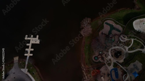 Aerial view of Jacobson Park lake playground transitioning to water surface, flying over to reveal skyline of the city of Lexington, Kentucky USA  photo