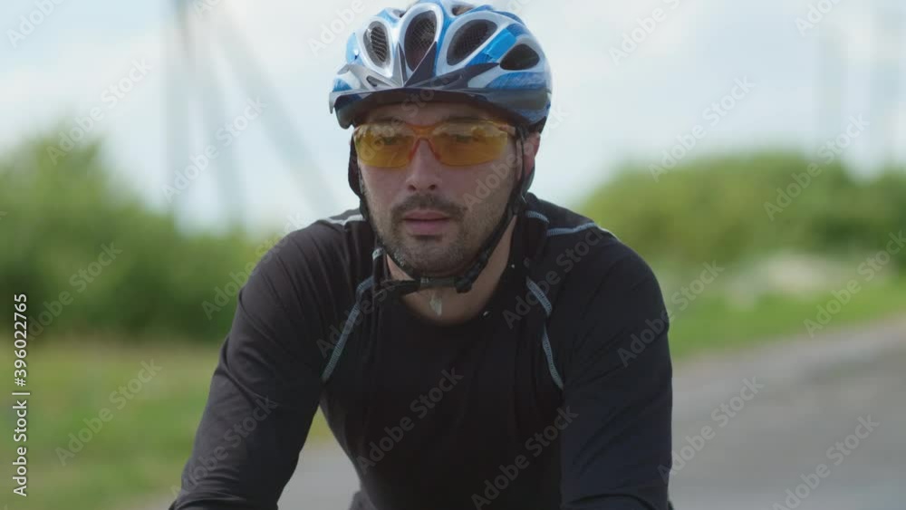 A professional cyclist in sports gear moves along an open paved road, beautiful nature on the horizon on a Sunny day. Selective focus A professional cyclist in sports gear moves along an open paved road, beautiful nature on the horizon on a Sunny day. Selective focus